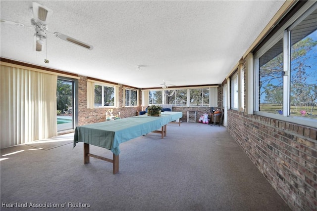 3150 Schontag Rd, Wauchula, FL 33873 - recreation room featuring brick wall, a textured ceiling, a ceiling fan, and carpet flooring