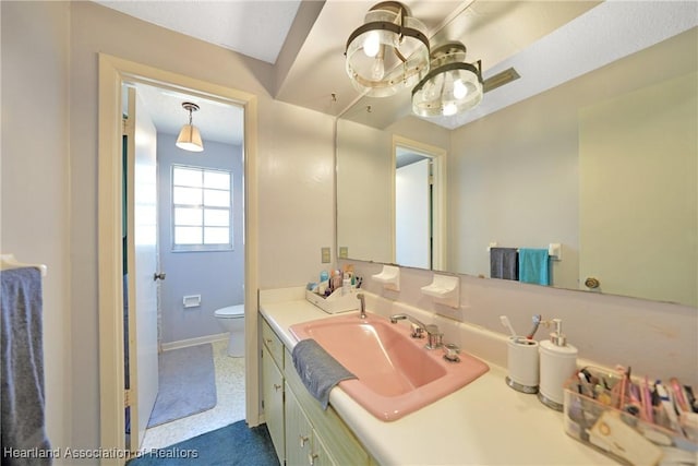 3150 Schontag Rd, Wauchula, FL 33873 - bathroom with toilet, visible vents, baseboards, and vanity