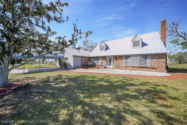 3150 Schontag Rd, Wauchula, FL 33873 - cape cod house featuring a front yard, brick siding, metal roof, and a chimney