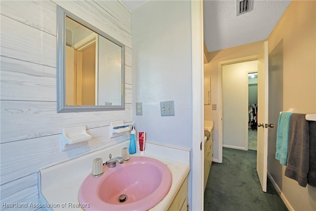 3150 Schontag Rd, Wauchula, FL 33873 - bathroom with baseboards, visible vents, a textured ceiling, and vanity