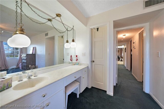 3150 Schontag Rd, Wauchula, FL 33873 - bathroom with a textured ceiling, vanity, visible vents, and baseboards