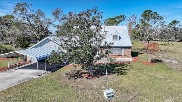 3150 Schontag Rd, Wauchula, FL 33873 - view of front facade featuring brick siding, a detached carport, concrete driveway, metal roof, and a front lawn
