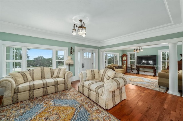 living room with ornate columns, plenty of natural light, a chandelier, and wood-type flooring