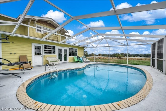 view of swimming pool featuring a lanai, a patio, and french doors