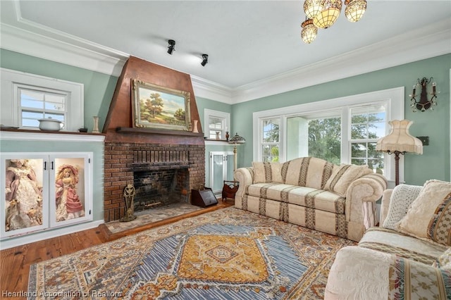 living room featuring hardwood / wood-style flooring, a brick fireplace, and crown molding