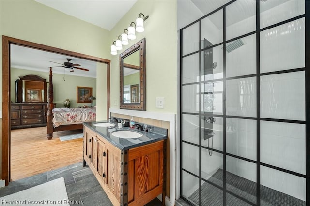 bathroom featuring walk in shower, vanity, ceiling fan, crown molding, and wood-type flooring