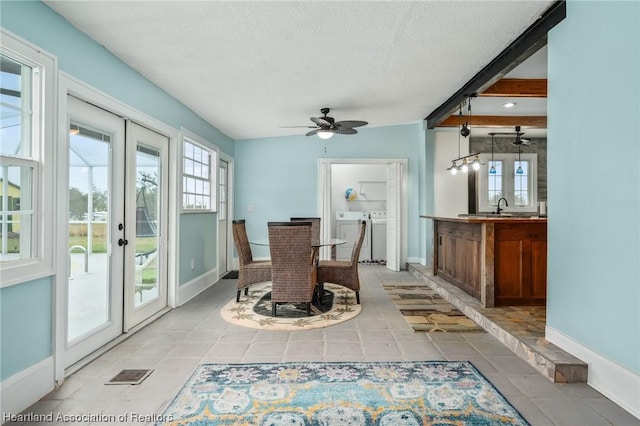 unfurnished dining area with french doors, a textured ceiling, ceiling fan, sink, and separate washer and dryer