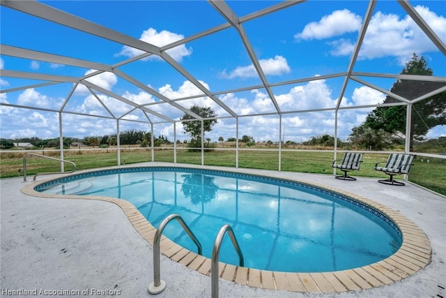 view of swimming pool featuring a lanai, a patio area, and a lawn