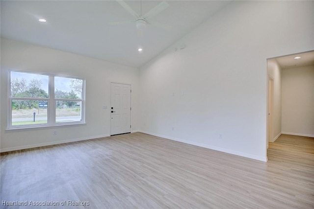 empty room featuring light wood-type flooring, high vaulted ceiling, a ceiling fan, recessed lighting, and baseboards