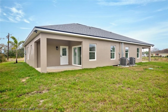 rear view of house with a patio area, a lawn, and stucco siding