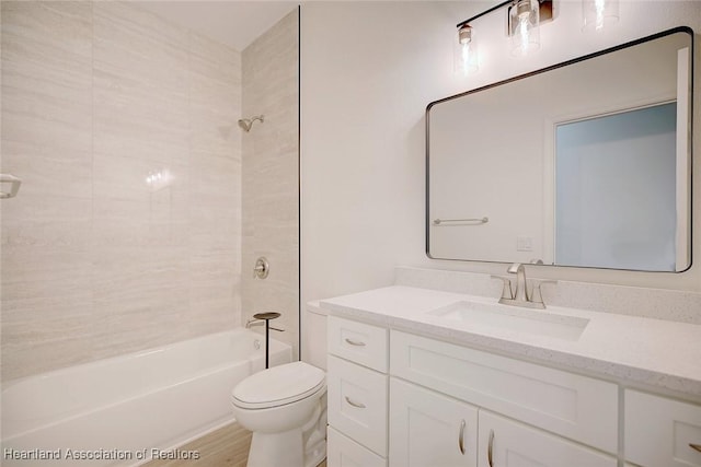 bathroom featuring vanity, toilet, wood finished floors, and  shower combination