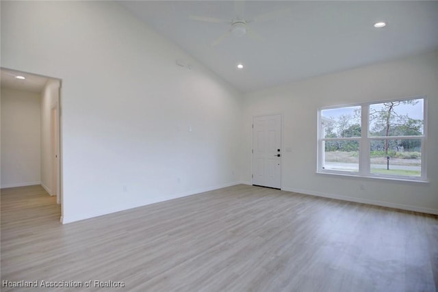 unfurnished room with baseboards, ceiling fan, light wood-type flooring, recessed lighting, and high vaulted ceiling