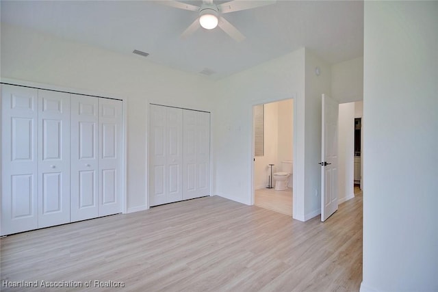 unfurnished bedroom featuring light wood-type flooring, multiple closets, visible vents, baseboards, and ceiling fan