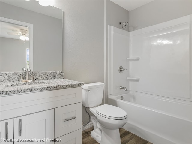 full bathroom featuring vanity, hardwood / wood-style flooring, ceiling fan, toilet, and shower / bath combination