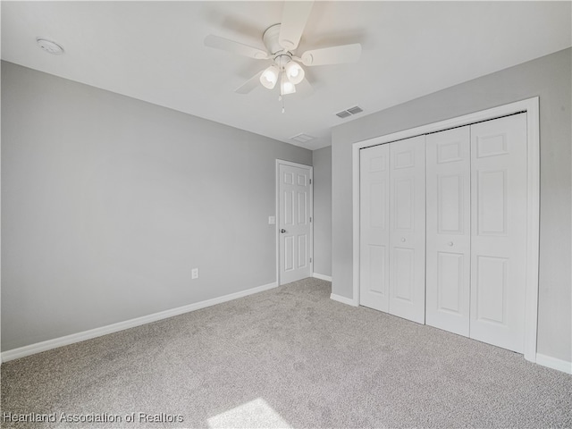 unfurnished bedroom with carpet flooring, ceiling fan, and a closet