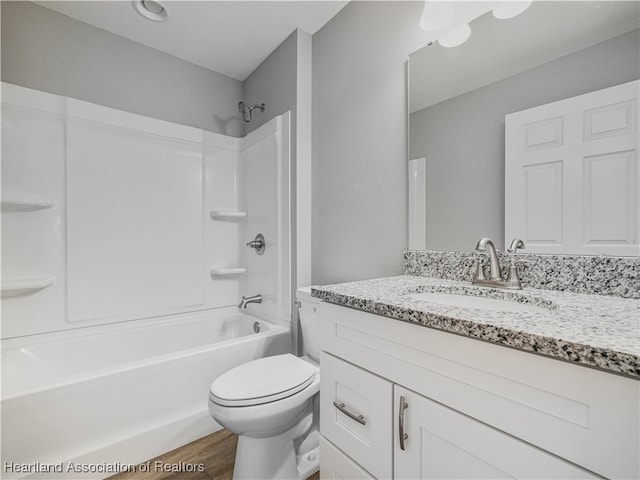 full bathroom featuring vanity, wood-type flooring, bathtub / shower combination, and toilet