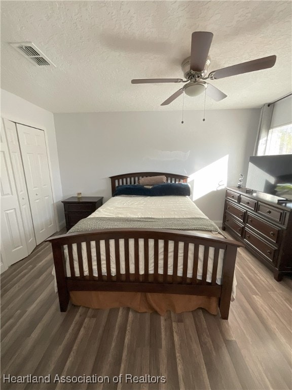 bedroom featuring ceiling fan, a closet, wood-type flooring, and a textured ceiling