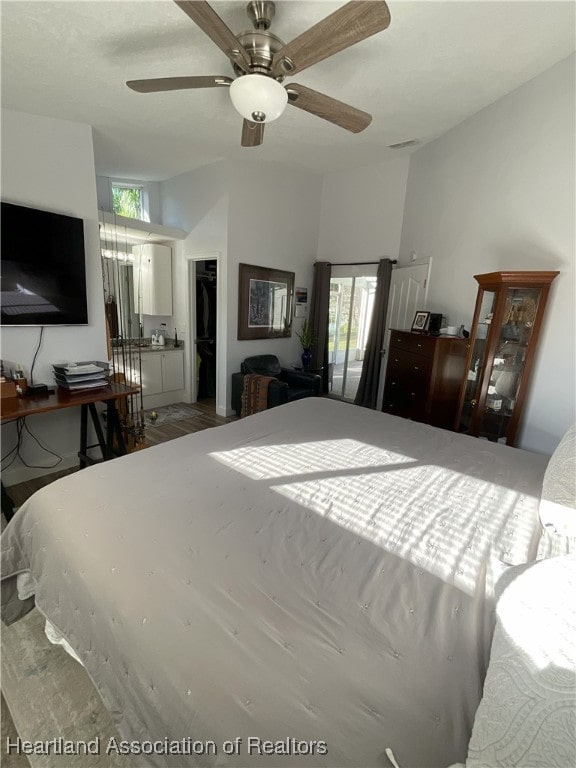 bedroom featuring multiple windows, a walk in closet, a closet, and ceiling fan