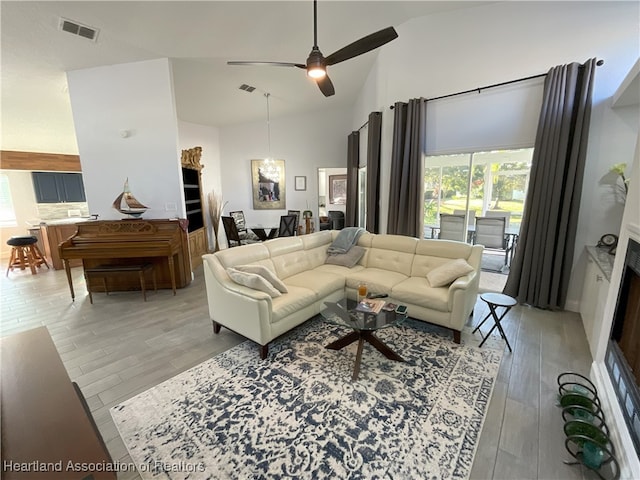 living room with high vaulted ceiling, light hardwood / wood-style flooring, and ceiling fan