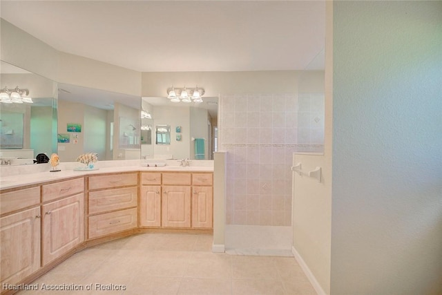 bathroom featuring a tile shower, tile patterned floors, and vanity