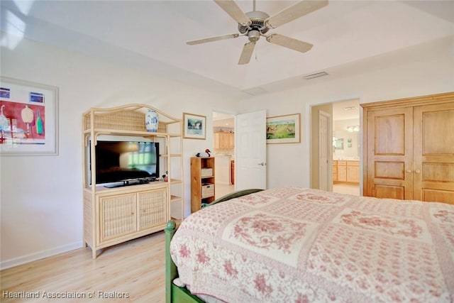 bedroom featuring hardwood / wood-style floors, ceiling fan, and connected bathroom