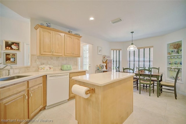 kitchen featuring sink, a healthy amount of sunlight, hanging light fixtures, white dishwasher, and light brown cabinetry