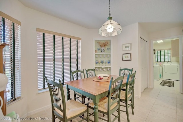 dining room featuring light tile patterned floors and washing machine and dryer