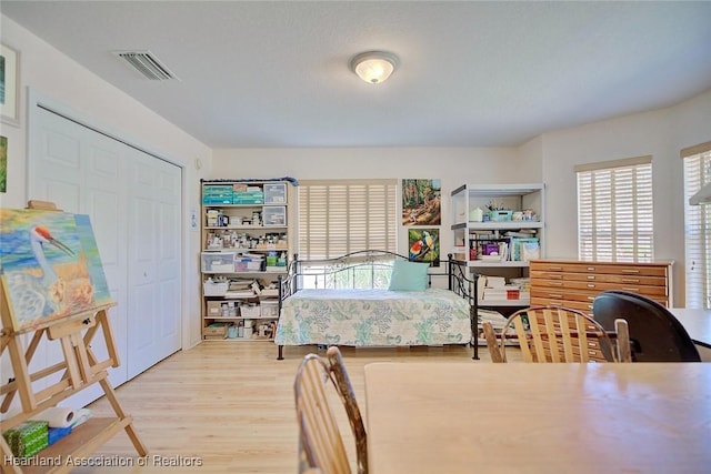 bedroom with light hardwood / wood-style flooring and a closet