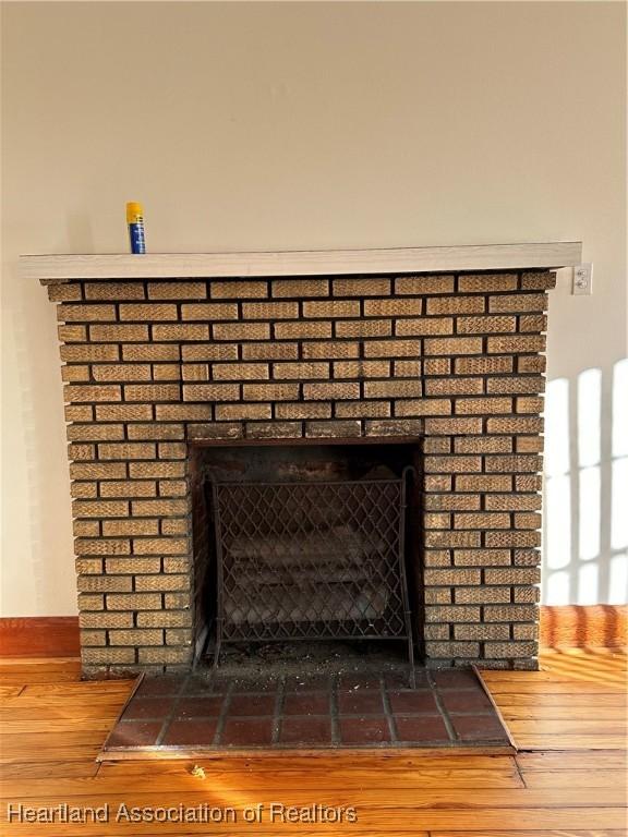 details featuring wood-type flooring and a brick fireplace