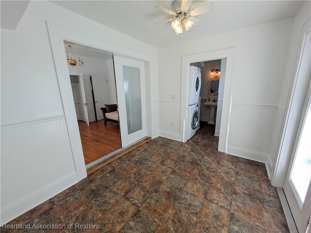 unfurnished bedroom with french doors, ceiling fan, a closet, and stacked washer and clothes dryer