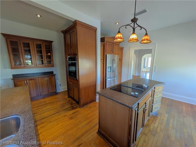 kitchen with pendant lighting, a center island, sink, appliances with stainless steel finishes, and a chandelier