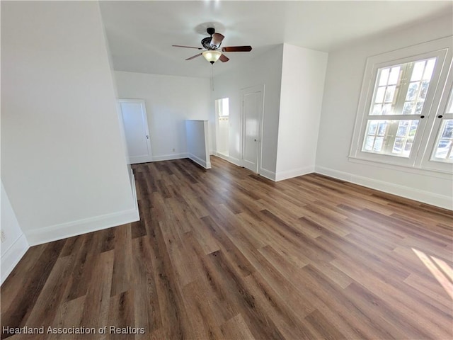 unfurnished living room with ceiling fan and dark wood-type flooring