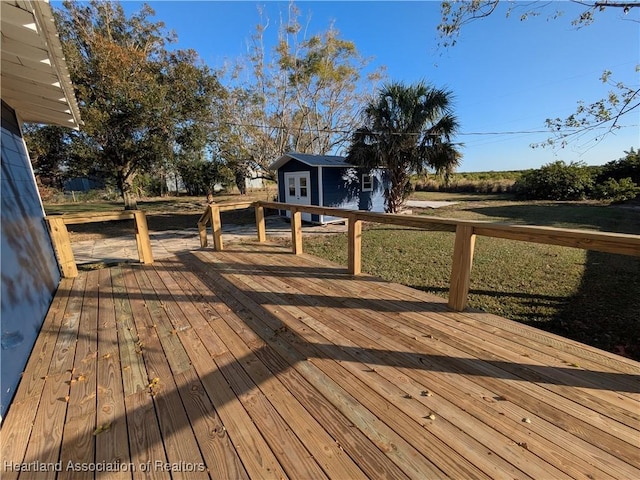 wooden deck featuring a lawn and an outdoor structure