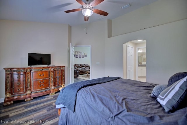 2112 Coral Ct, Sebring, FL 33870 - bedroom with arched walkways, wood finished floors, ceiling fan, ensuite bathroom, and high vaulted ceiling