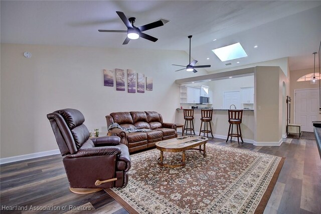 2112 Coral Ct, Sebring, FL 33870 - living room with a skylight, a ceiling fan, dark wood finished floors, vaulted ceiling, and baseboards