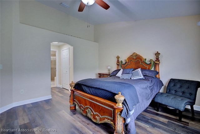2112 Coral Ct, Sebring, FL 33870 - bedroom featuring arched walkways, wood finished floors, baseboards, ensuite bathroom, and a ceiling fan