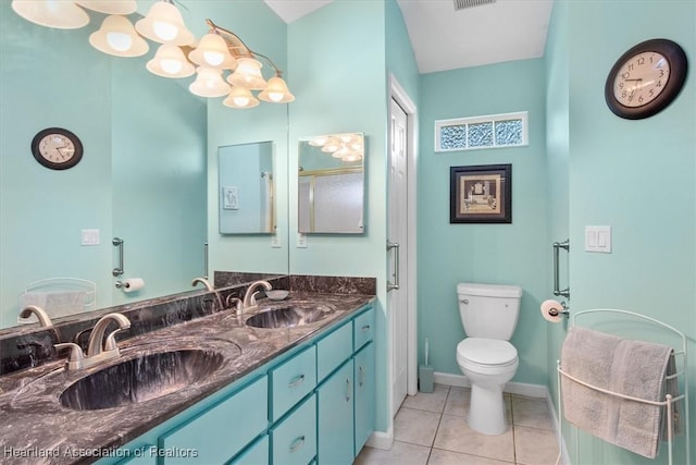 bathroom with toilet, vanity, and tile patterned flooring