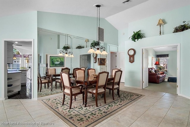 tiled dining room with high vaulted ceiling and a chandelier