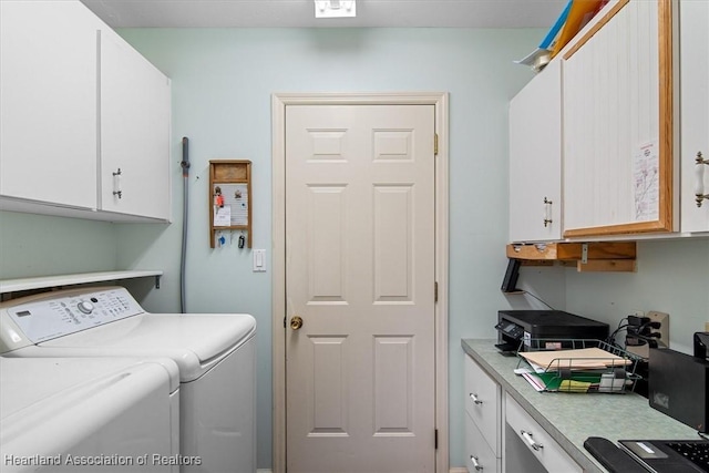 laundry room featuring washer and dryer and cabinets