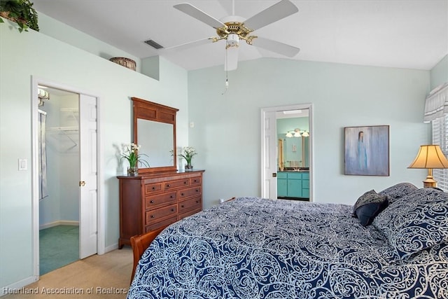 carpeted bedroom featuring a walk in closet, a closet, vaulted ceiling, ceiling fan, and ensuite bathroom