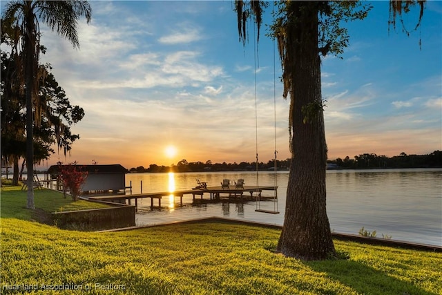 view of dock featuring a water view and a yard