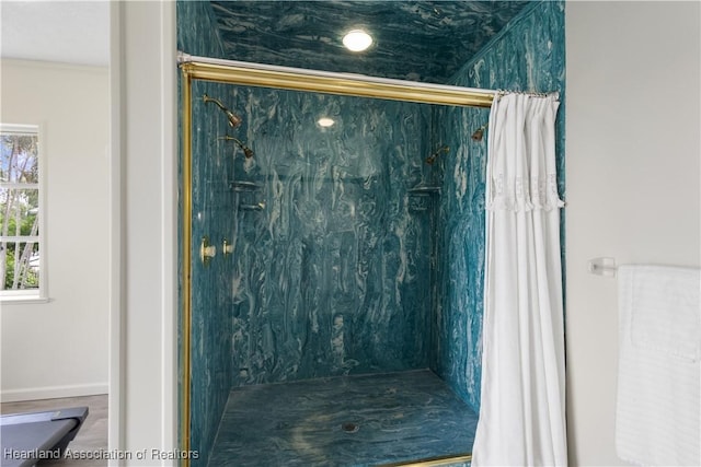 bathroom featuring baseboards and a shower stall