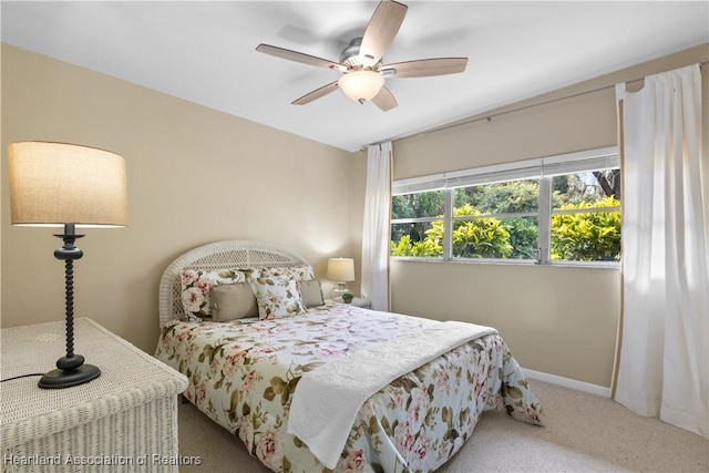 carpeted bedroom with baseboards and a ceiling fan