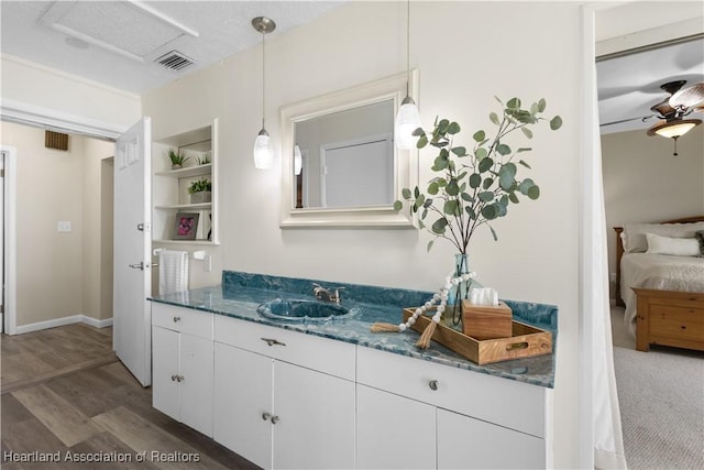 ensuite bathroom featuring visible vents, ensuite bathroom, built in shelves, vanity, and wood finished floors