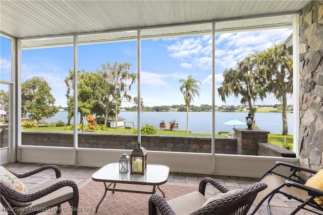 sunroom / solarium featuring a water view