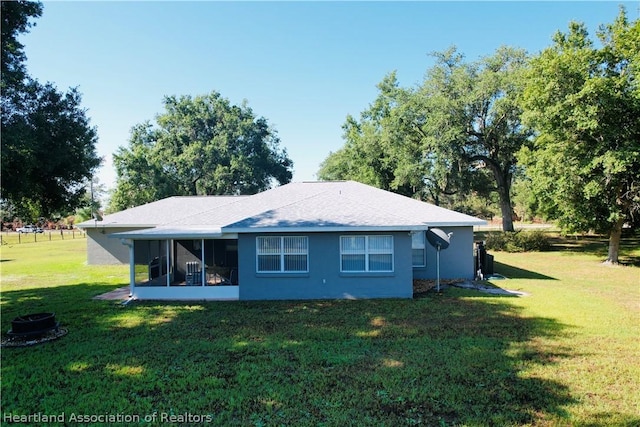 back of property featuring a sunroom and a yard