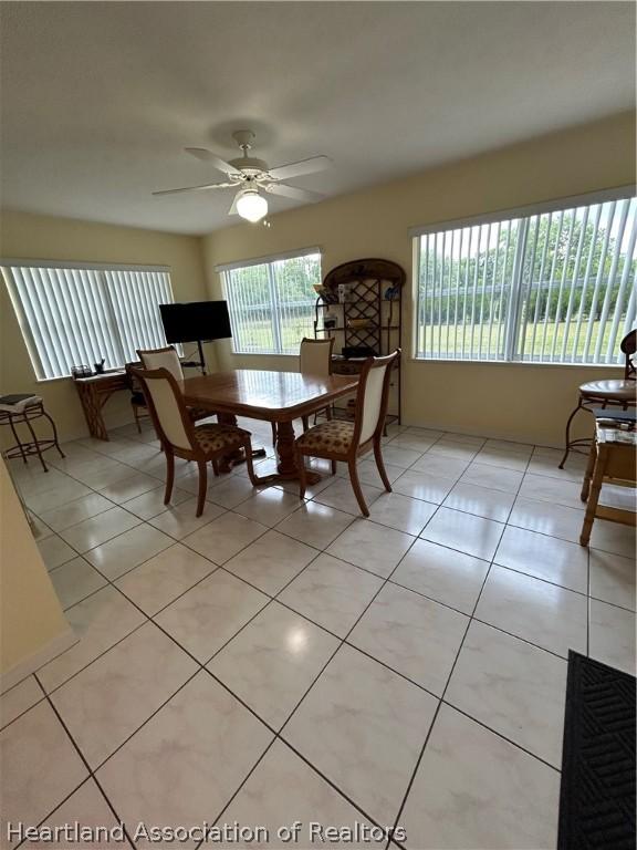 dining area with light tile patterned floors, ceiling fan, and a healthy amount of sunlight