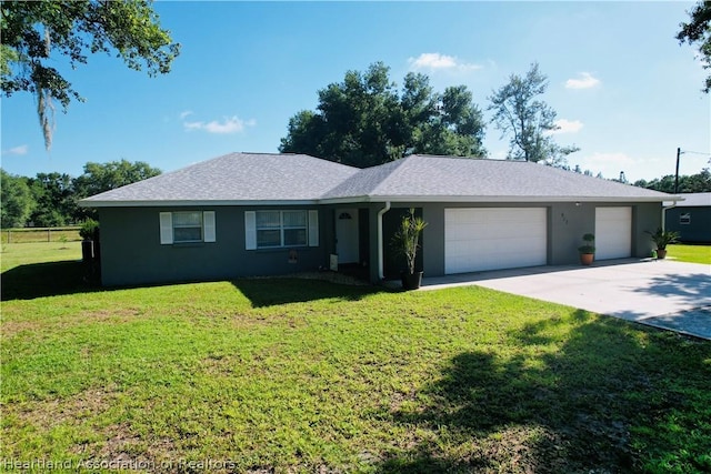 ranch-style home with a garage and a front lawn