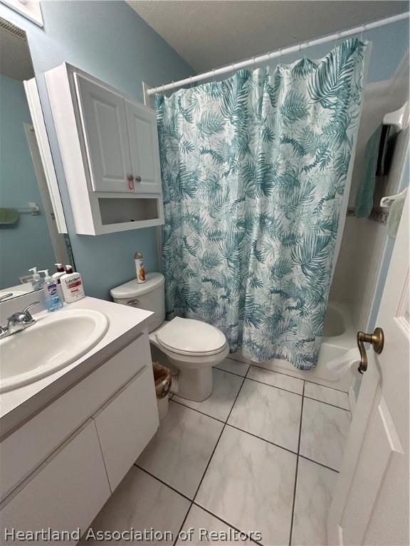 full bathroom with tile patterned floors, vanity, shower / bath combo, and toilet