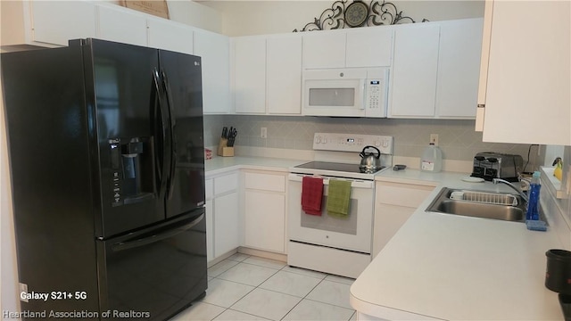 kitchen with tasteful backsplash, white appliances, sink, light tile patterned floors, and white cabinets